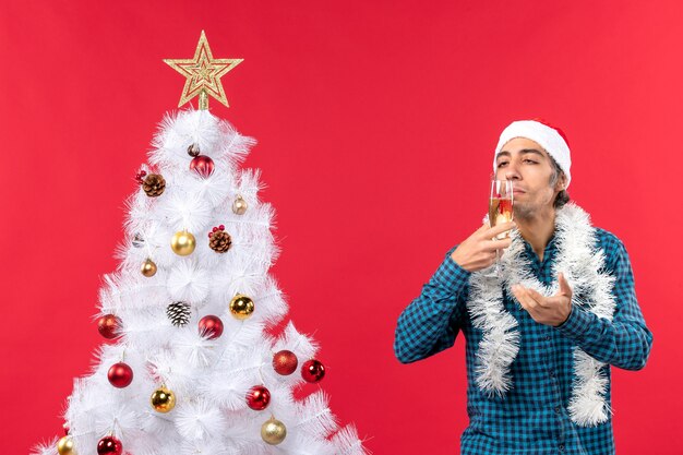 A man is standing next to the Christmas tree