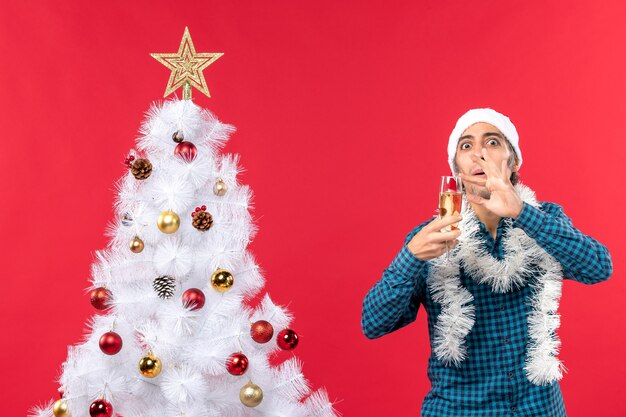 A man is standing next to the Christmas tree