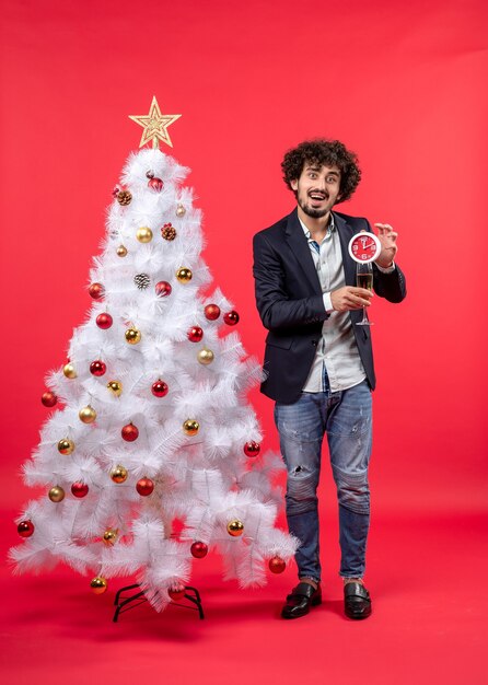 Un uomo è in piedi vicino all'albero di natale