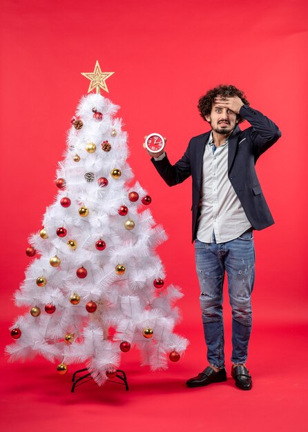 Free photo a man is standing next to the christmas tree