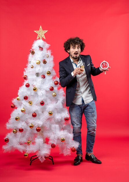 A man is standing next to the Christmas tree