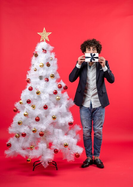 クリスマスツリーの横に男が立っています