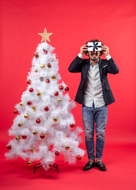 A man is standing next to the Christmas tree