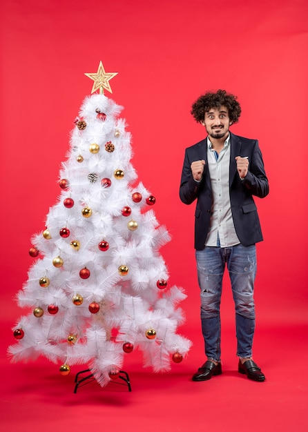 Un uomo è in piedi vicino all'albero di natale