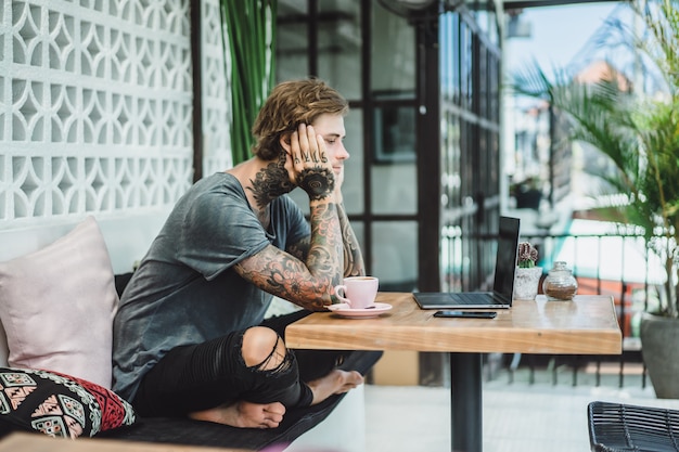 man is working in a cafe. concept of freelancing, coffee and laptop