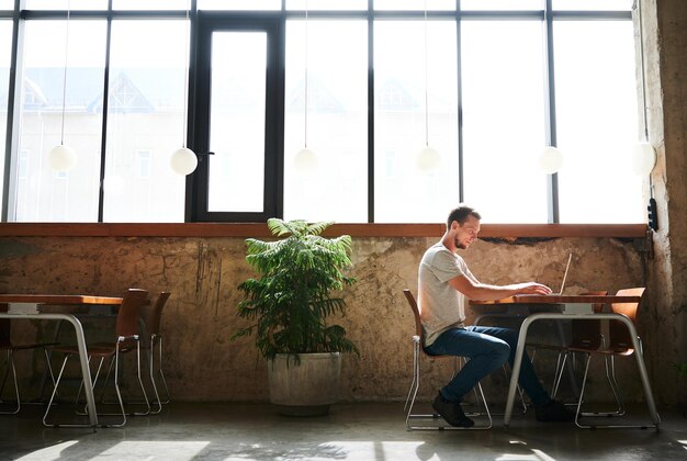 Man is working on laptop in cafe