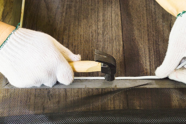 Man is working with mosquito wire screen installation