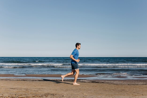 Человек бег трусцой на пляже