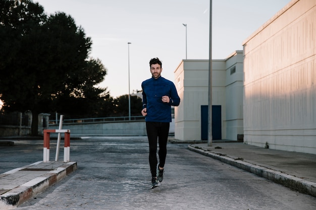 Free photo man jogging on street in dusk