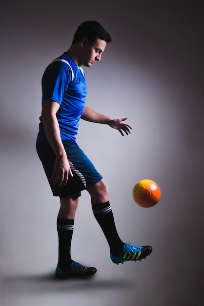 Бесплатное фото Человек жонглирует футболом