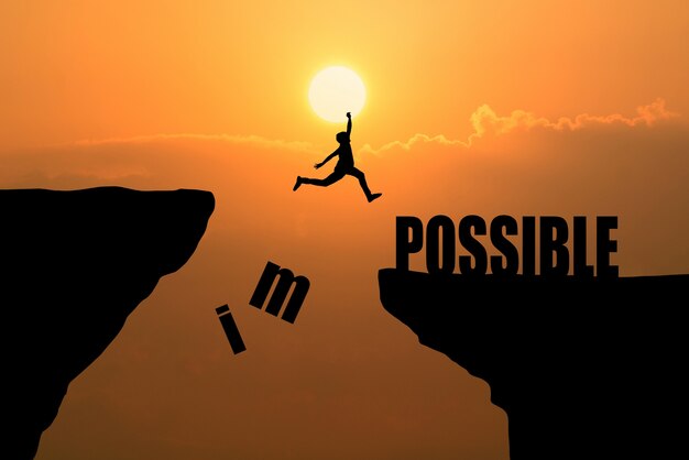 Man jumping over impossible or possible over cliff on sunset background,Business concept idea