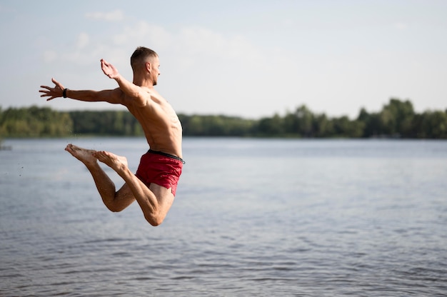 Человек прыгает в озере