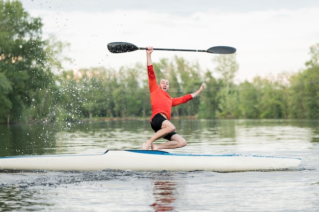 Free photo man jumping out of kayak