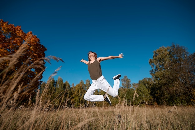 Free photo man jumping outside full shot