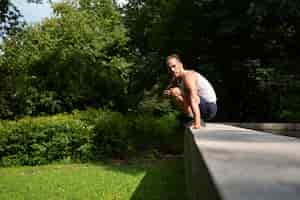 Free photo man jumping over stone fence