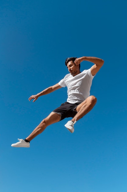 Free photo man jumping while doing parkour