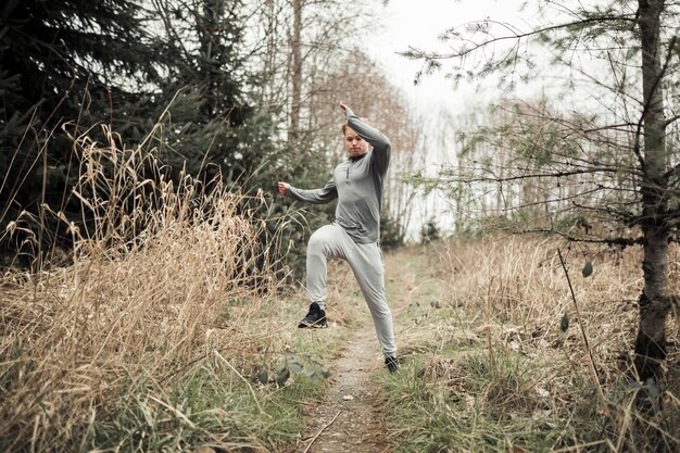 Man jumping while running on the forest trail