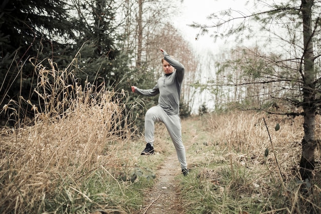 Man jumping while running on the forest trail