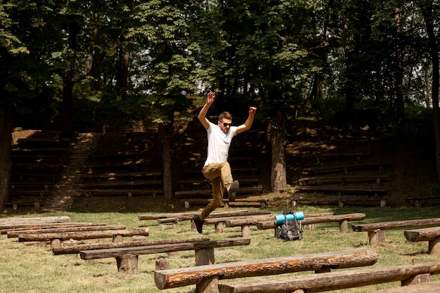 Free photo man jumping over wooden benches