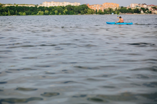 Foto gratuita un uomo in kayak sull'acqua increspava la superficie del lago