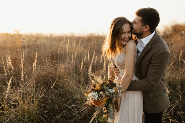 A man kisses his wife.  She laughs.