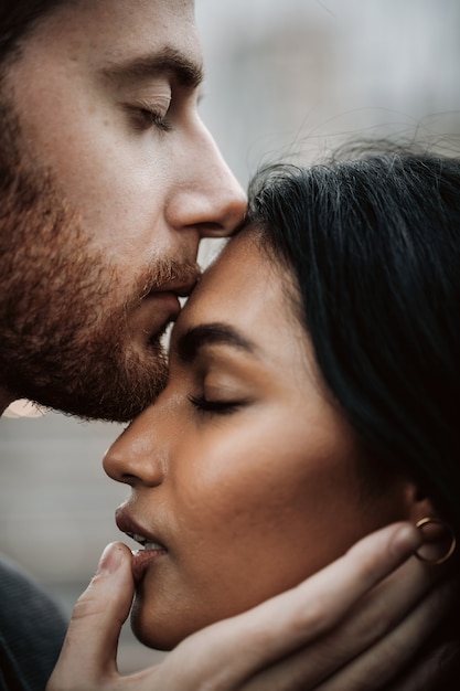 男は若いインド人の女性にキスをして、彼女を抱きしめている
