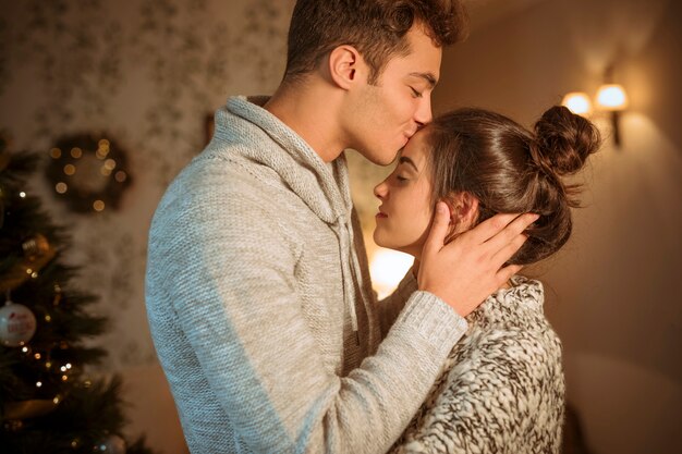 Man kissing girlfriend to forehead 