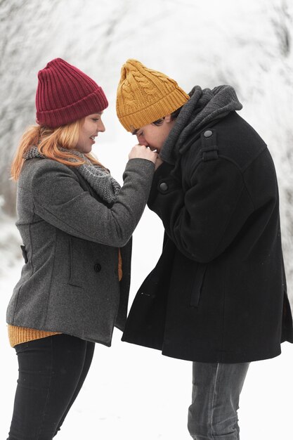 Man kissing her girlfriend's hands medium shot