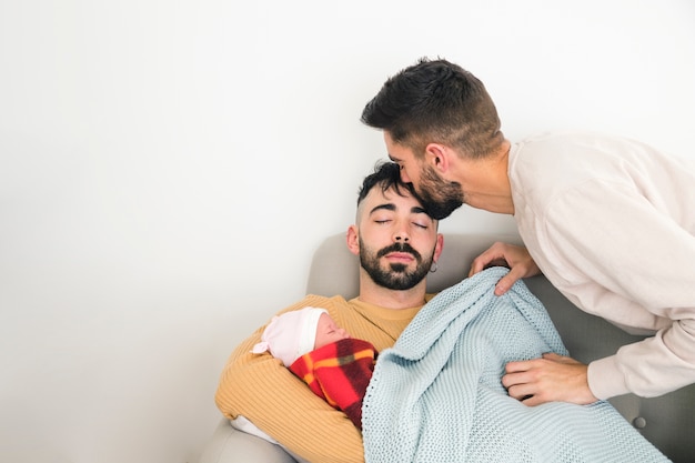 白い壁に赤ちゃんと一緒にソファで寝ている彼の彼氏の額にキスをする男 無料の写真 白い壁に赤ちゃんと一緒にソファで寝ている彼の彼氏の額にキスをする男 無料の写真