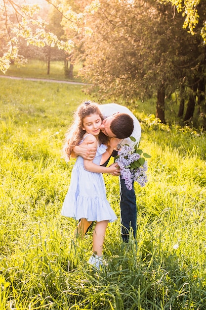 Uomo che bacia sua figlia nel parco