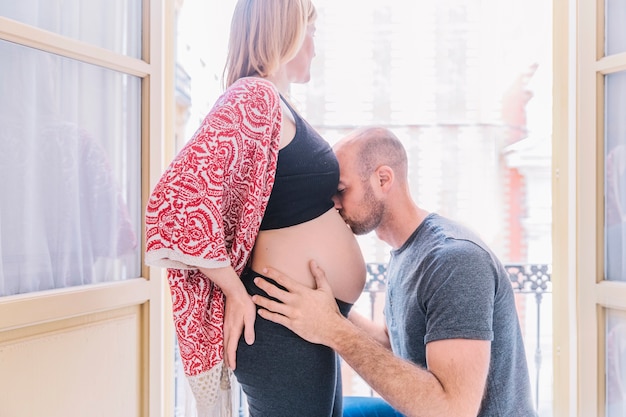 Мужчина целует беременную женщину
