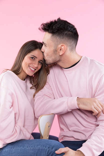 Man kissing smiling woman on chair