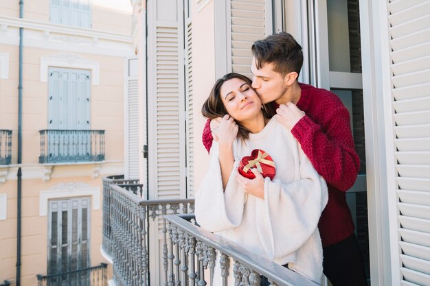 Man kissing woman on balcony