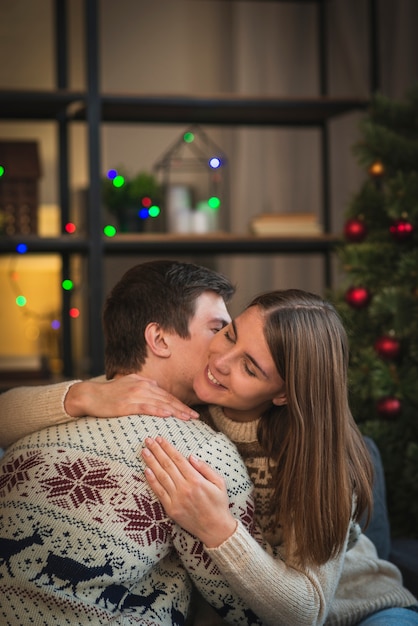 Free photo man kissing woman on cheek