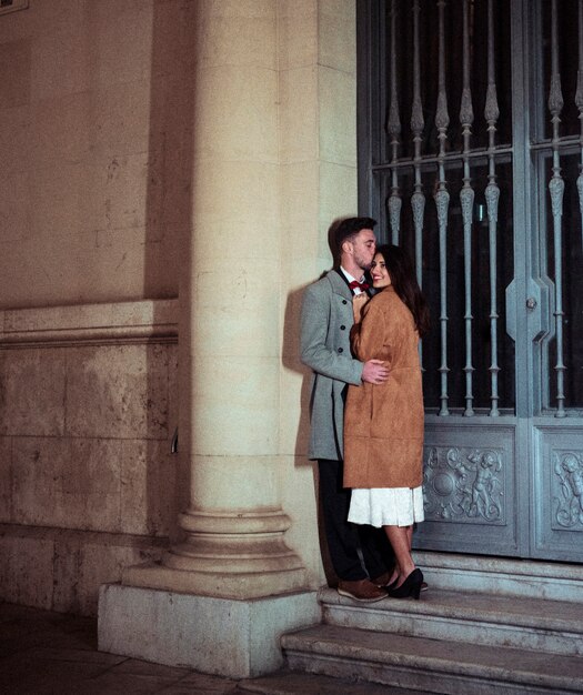 Man kissing woman on forehead in street 