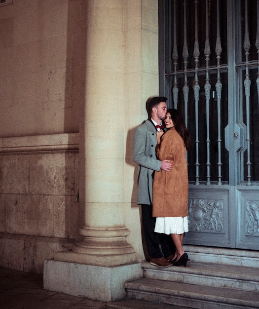 Мужчина целует женщину в лоб на улице