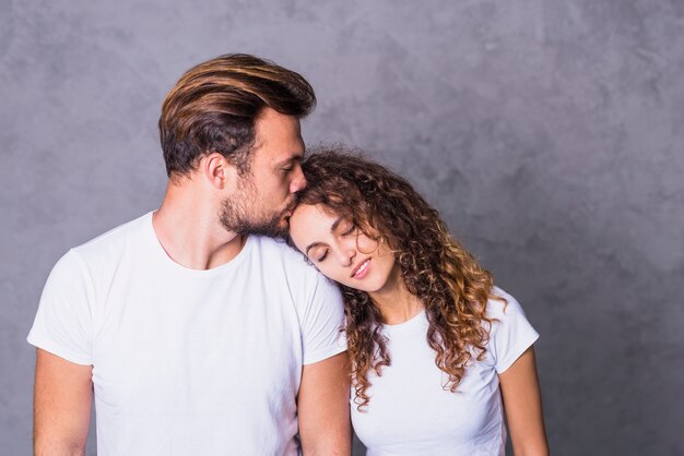 Man kissing woman on forehead 