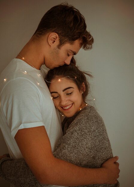 Man kissing woman on head 