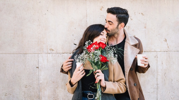 Man kissing woman with bouquet