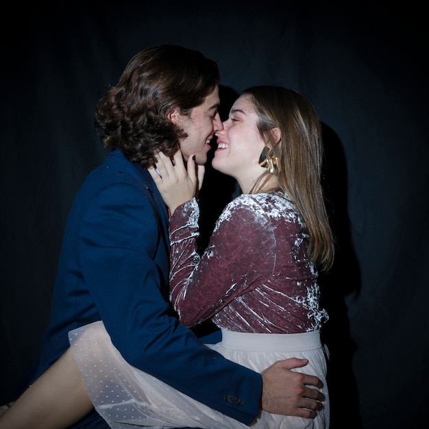 Free photo man kissing young woman in dress on party