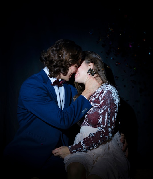 Man kissing young woman on party 