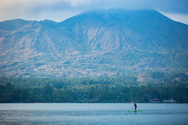 A man on the lake ride a sup board.