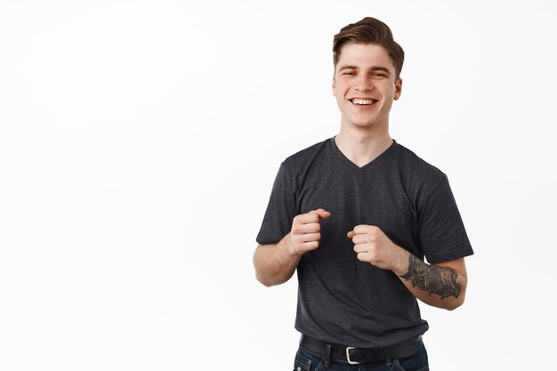  man laughing and holding fists clenched for good luck, standing on white, holding in hands