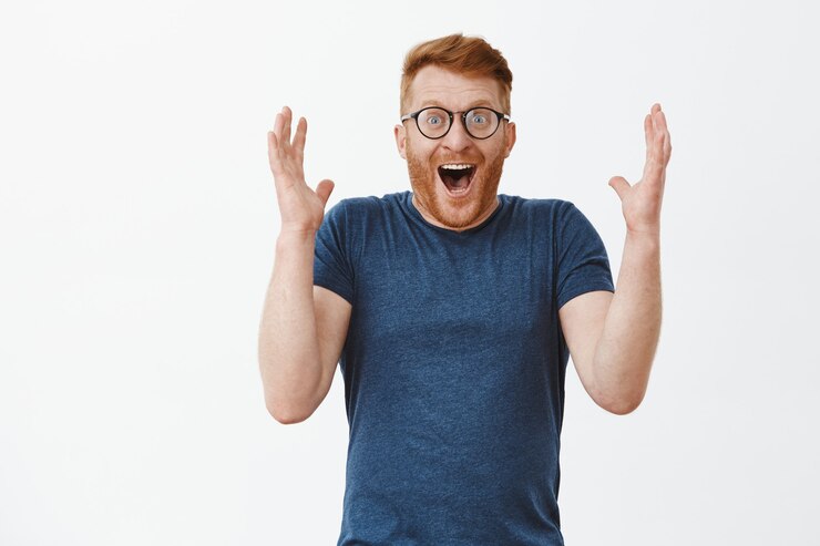 Free Photo man laughing joyfully from surprise and amazement, raising palms high smiling broadly and chuckling, being happy and astonished from happiness and joy