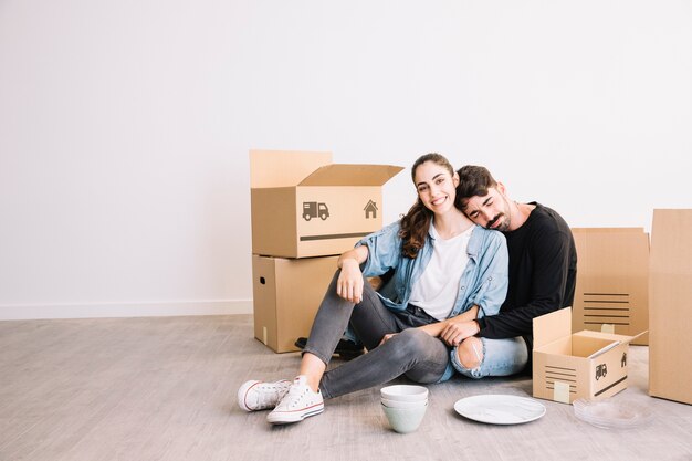 Man leaning against woman in front of moving boxes