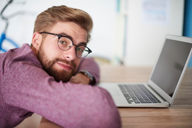 Foto gratuita uomo appoggiato sulla scrivania in ufficio