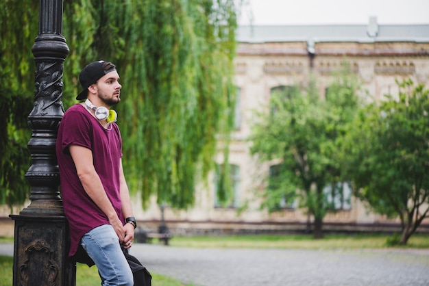 Man leaning on lamp post standing