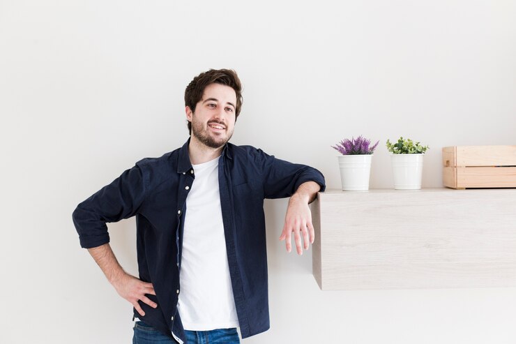 Free Photo man leaning on shelf near plants