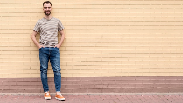 Man leaning on a wall copy space