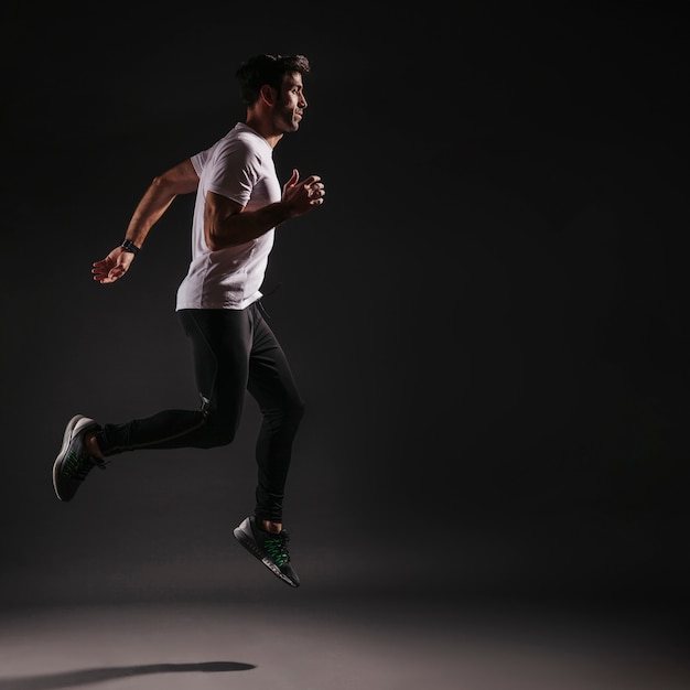 Man leaping on dark background